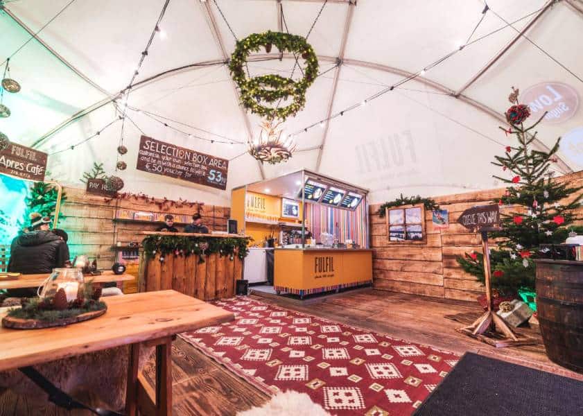 Vibrant interior of a Superior Tent Rentals festive event tent with wooden accents and holiday decor.