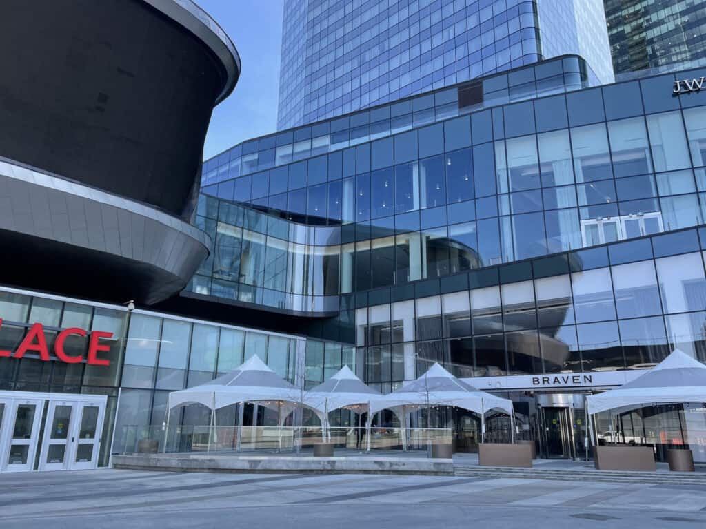 Modern glass building exterior with tented event space outside, ideal for corporate events and upscale parties.
