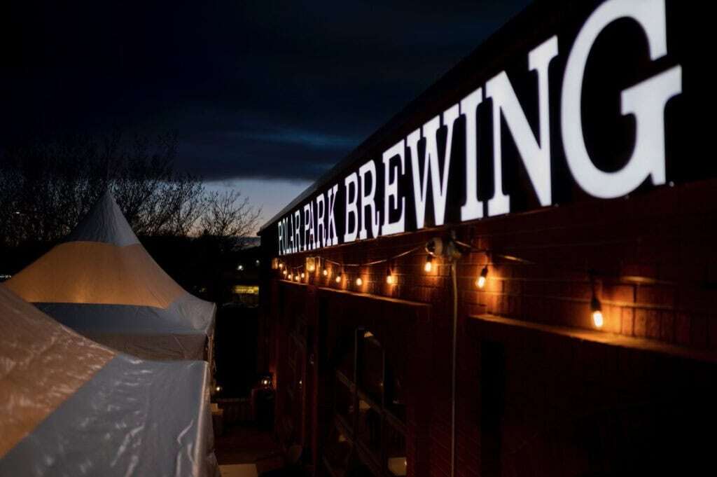 Bright illuminated sign at Superior Tent Rentals showcasing brewery event tent setup at Polar Park Brew Wing.