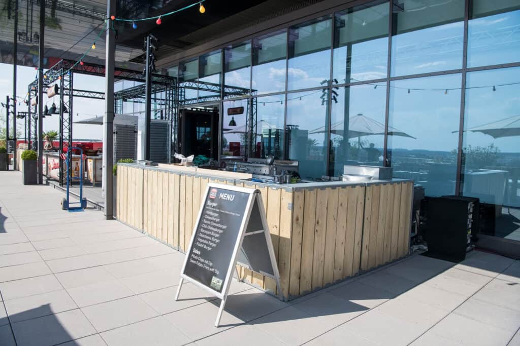 Modern outdoor event space with tent rentals and food service area at a rooftop venue.