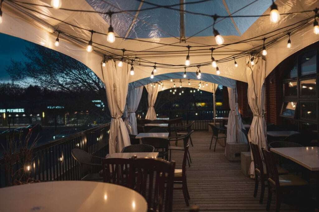 Elegant outdoor event tent with string lights and seating for weddings and parties.