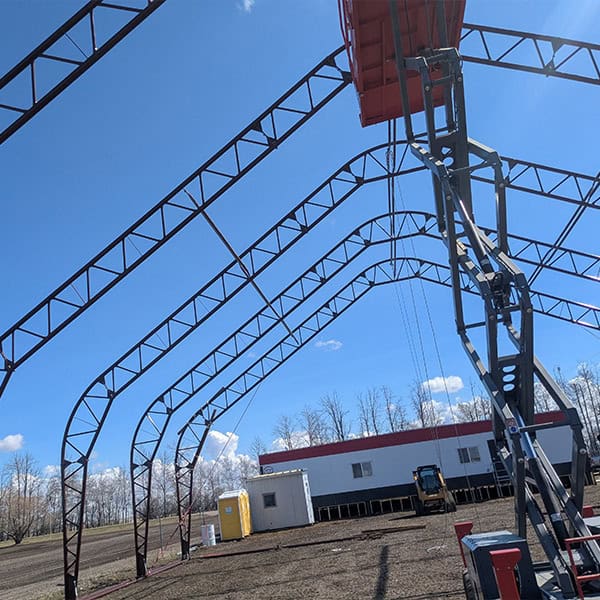 Unassembled large event tent frame on outdoor construction site, ready for installation for weddings, parties, or corporate events, provided by Superior Tent Rentals.