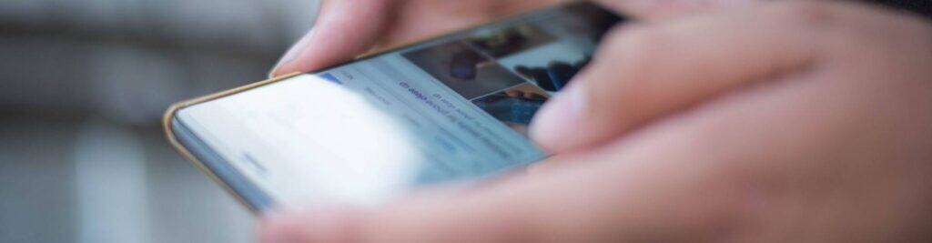 A person using a smartphone, browsing Superior Tent Rentals website.